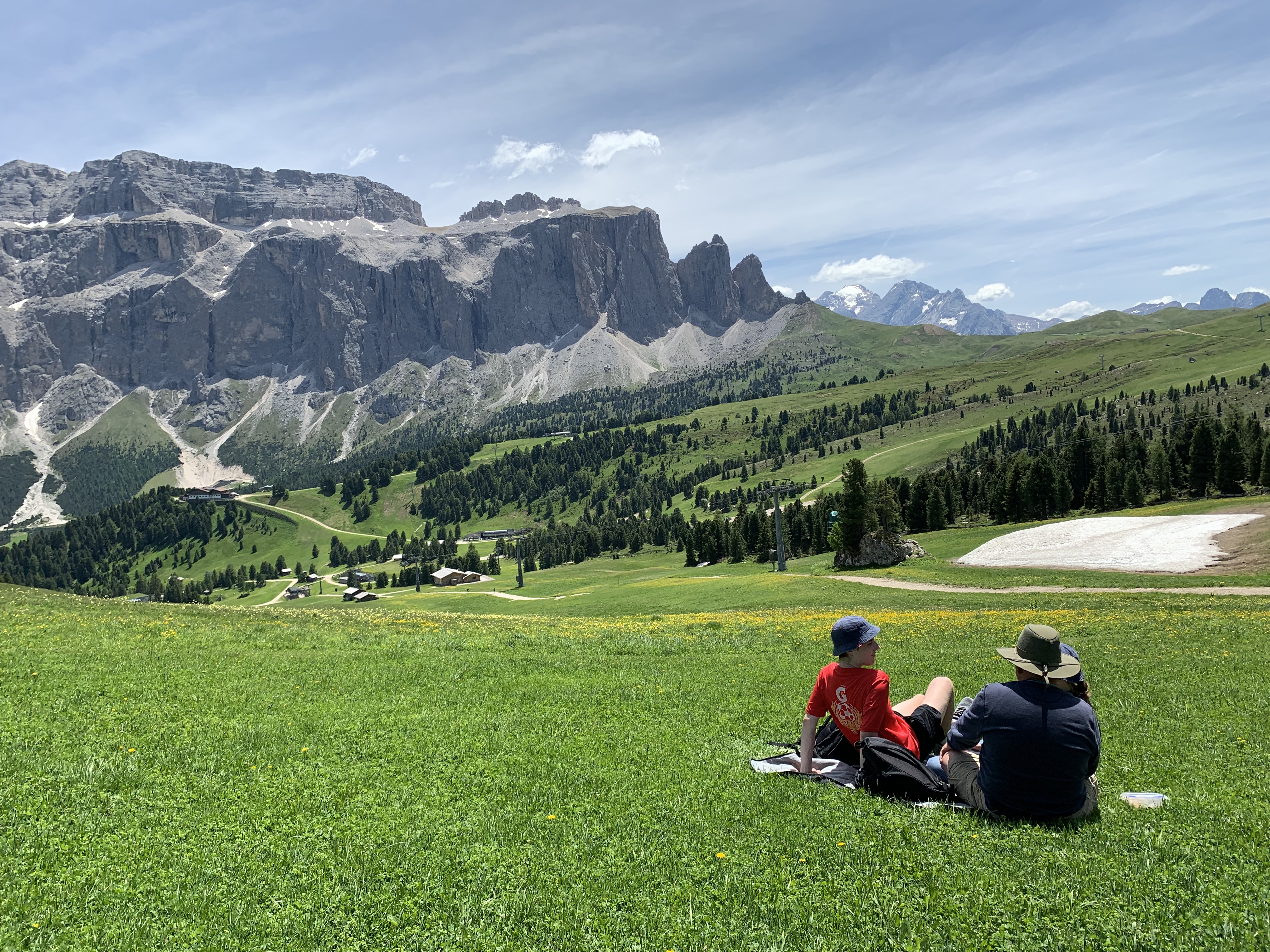 three people sat on a tarp overlooking a mountain