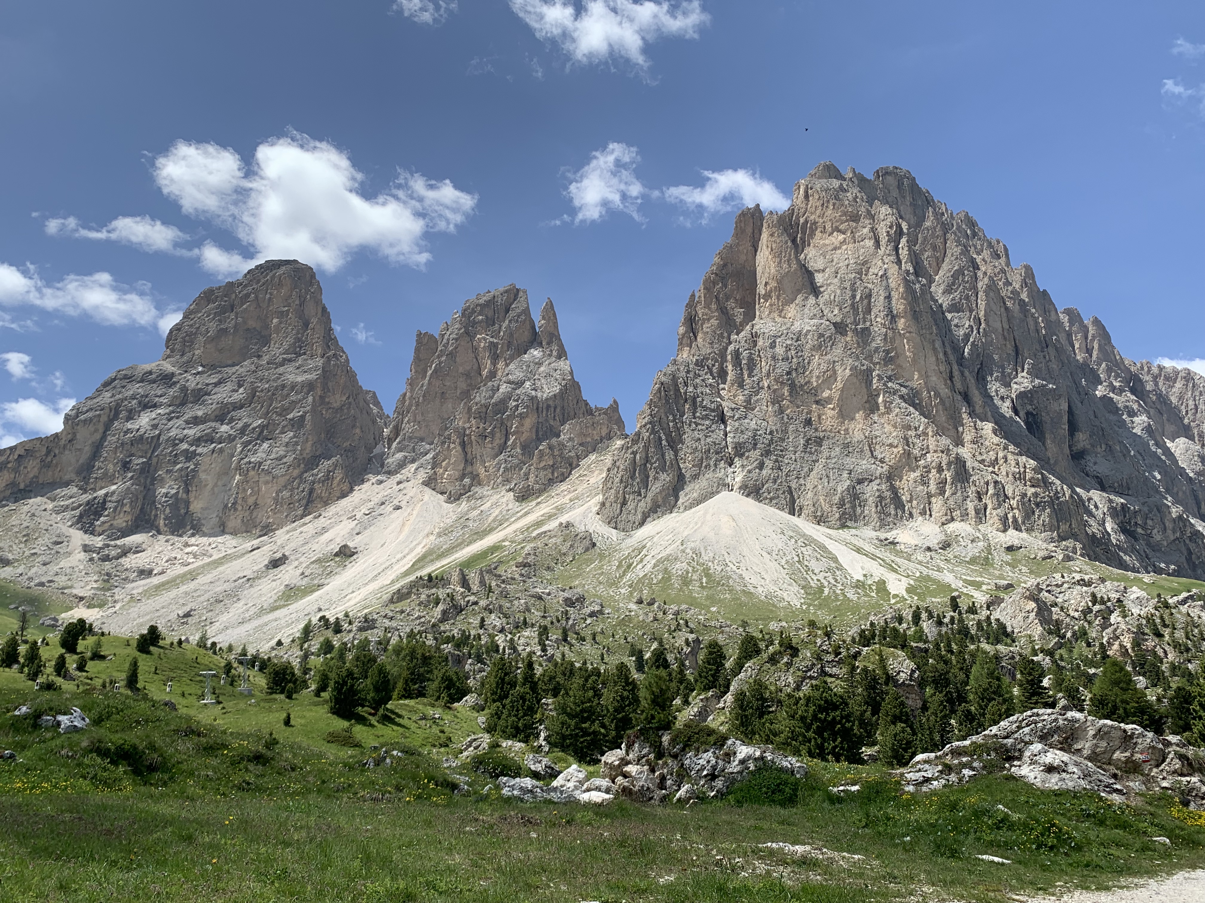 three large rocks surrounded by scree and grass