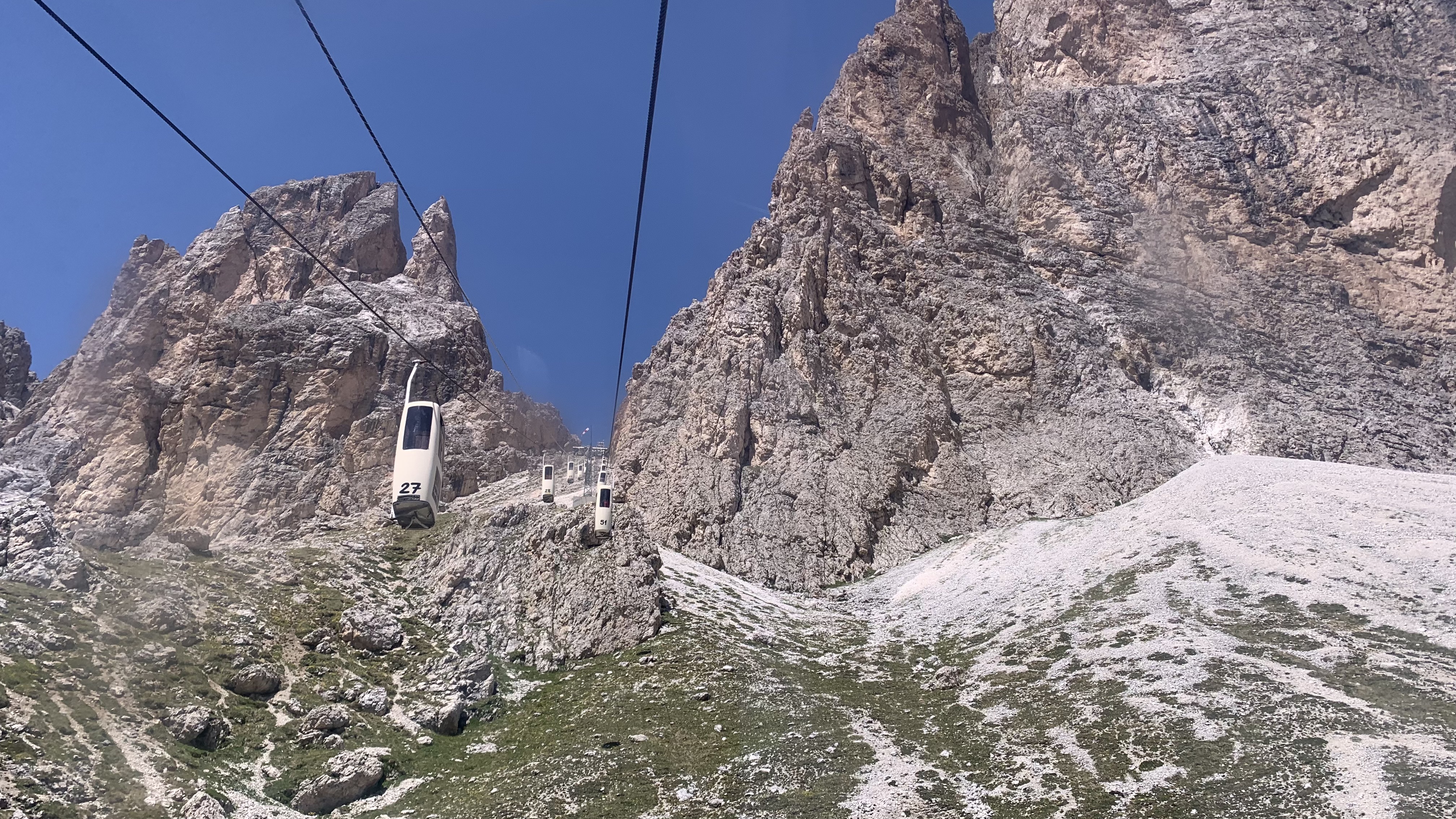 tall and thin cable cars traverse between mountains